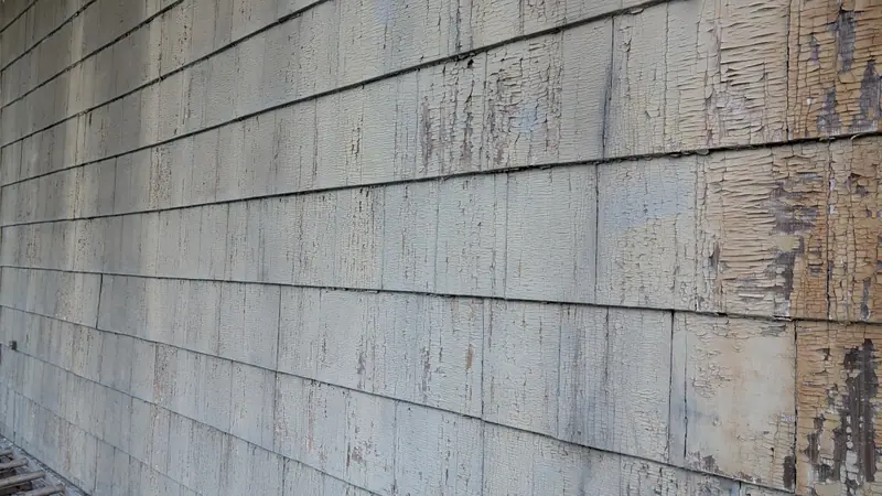 Peeling and cracked paint on exterior wood siding, the kind of condition cited in HPD lead paint violations