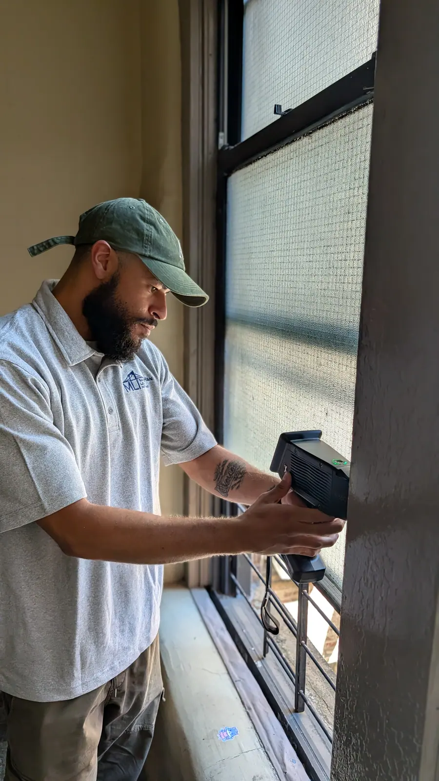 Manhattan Lead inspector holding an XRF analyzer against a window frame during a lead paint inspection