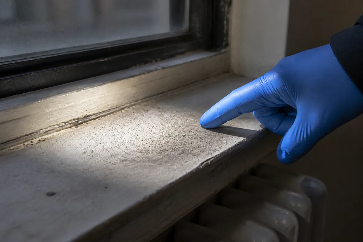 Fine residual dust visible on a window sill under inspection light