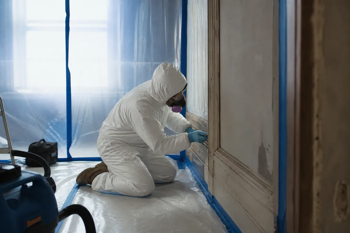 Qualified worker using lead-safe practices in a contained room
