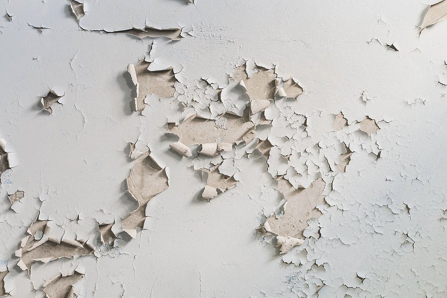 Peeling and flaking white paint on a wall